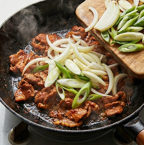 제육볶음 레시피 | 기본으로 완성되는 제육 조리 단계 4 이미지 - 달군 팬에 양념한 돼지고기를 넣고 중불에서 익힌다. 고기가 거의 익으면 