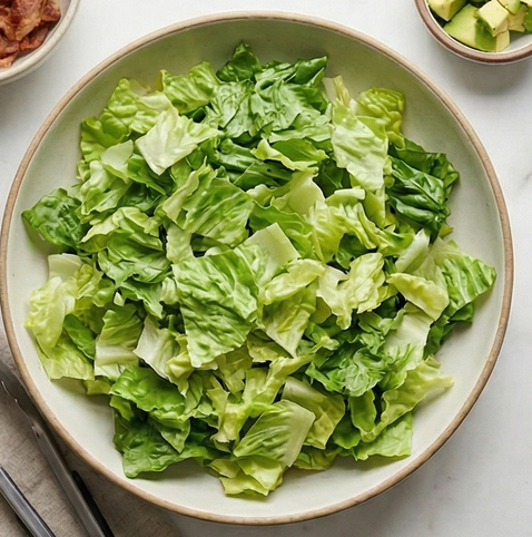 코브 샐러드 | 고단백 샐러드 조리 단계 3 이미지 - 넓은 접시에 준비한 로메인 또는 양상추를 고르게 펼쳐 베이스를 만듭니다.