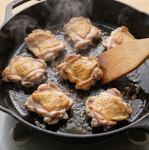 허니 갈릭 치킨 조리 단계 2 이미지 - 달군 팬에 식용유를 두르고 닭다리살을 앞뒤로 노릇하게 굽습니다.