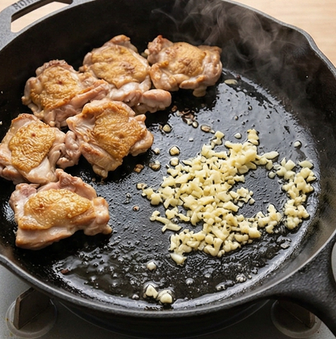 허니 갈릭 치킨 조리 단계 3 이미지 - 닭고기를 팬에서 잠시 꺼낸 뒤, 같은 팬에 다진 마늘을 중약불에서 향이 