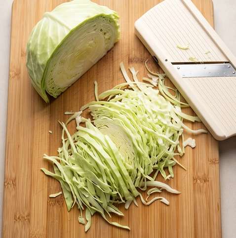 양배추 샐러드 | 일본식 캬베츠 사라다 황금 비율 드레싱 조리 단계 1 이미지 - 양배추를 최대한 얇게 채 썬다. 칼이나 채칼을 이용해 가늘고 고르게 써는