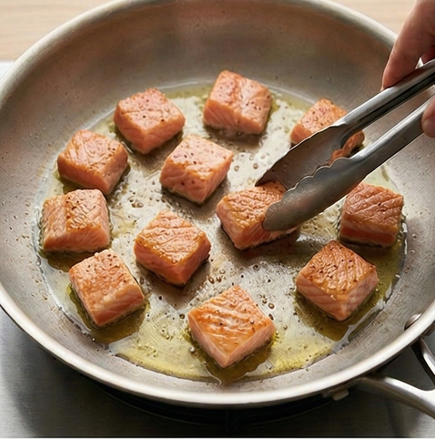 연어 아보카도 샐러드 | 단백질과 오메가 3 조리 단계 2 이미지 - 연어 큐브에 소금과 후추를 고루 뿌려 밑간한 후, 달군 팬에 올리브오일 